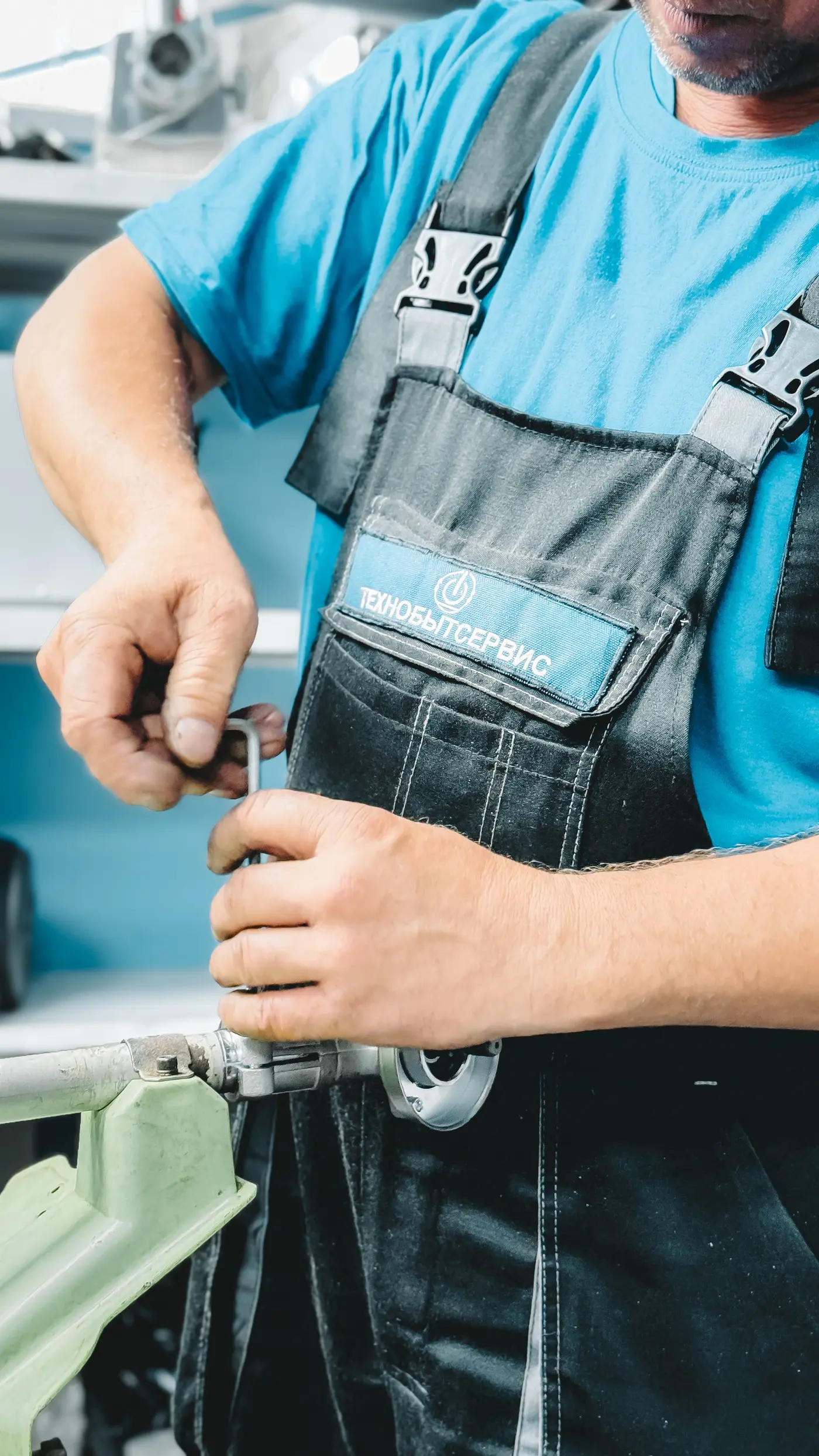 Plumber turning a wrench on a pipe connection during a drain service call