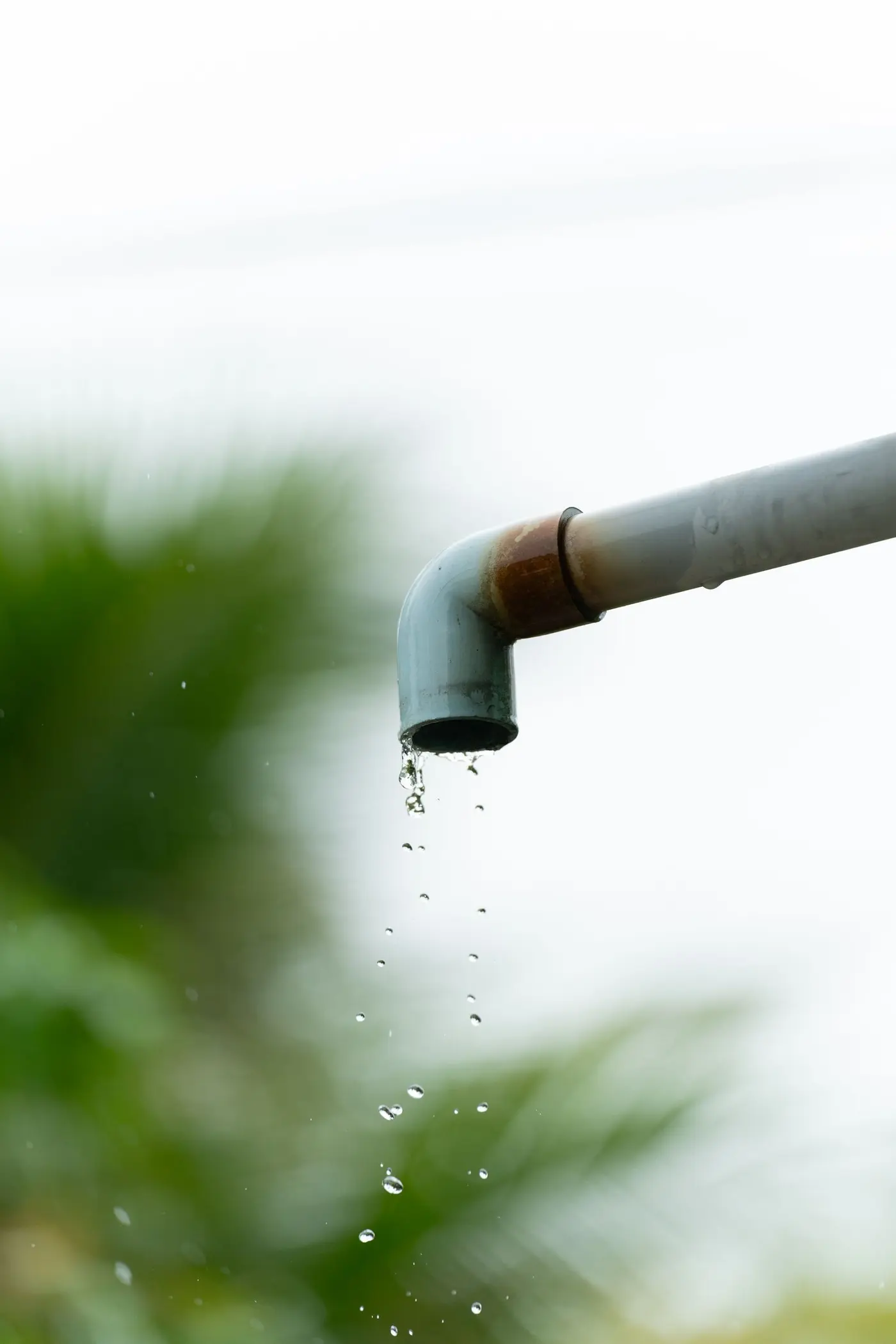 Water dripping from the open end of a corroded pipe elbow