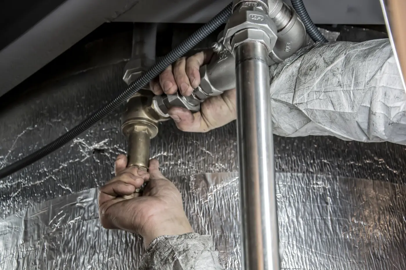 Licensed plumber fitting copper supply lines during a water heater install