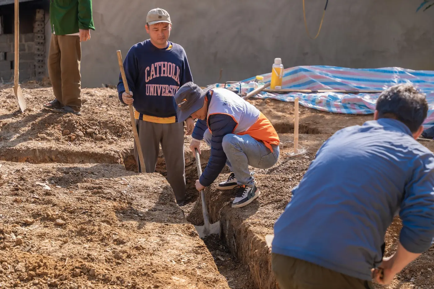 Crew digging a trench by hand ahead of underground pipe replacement