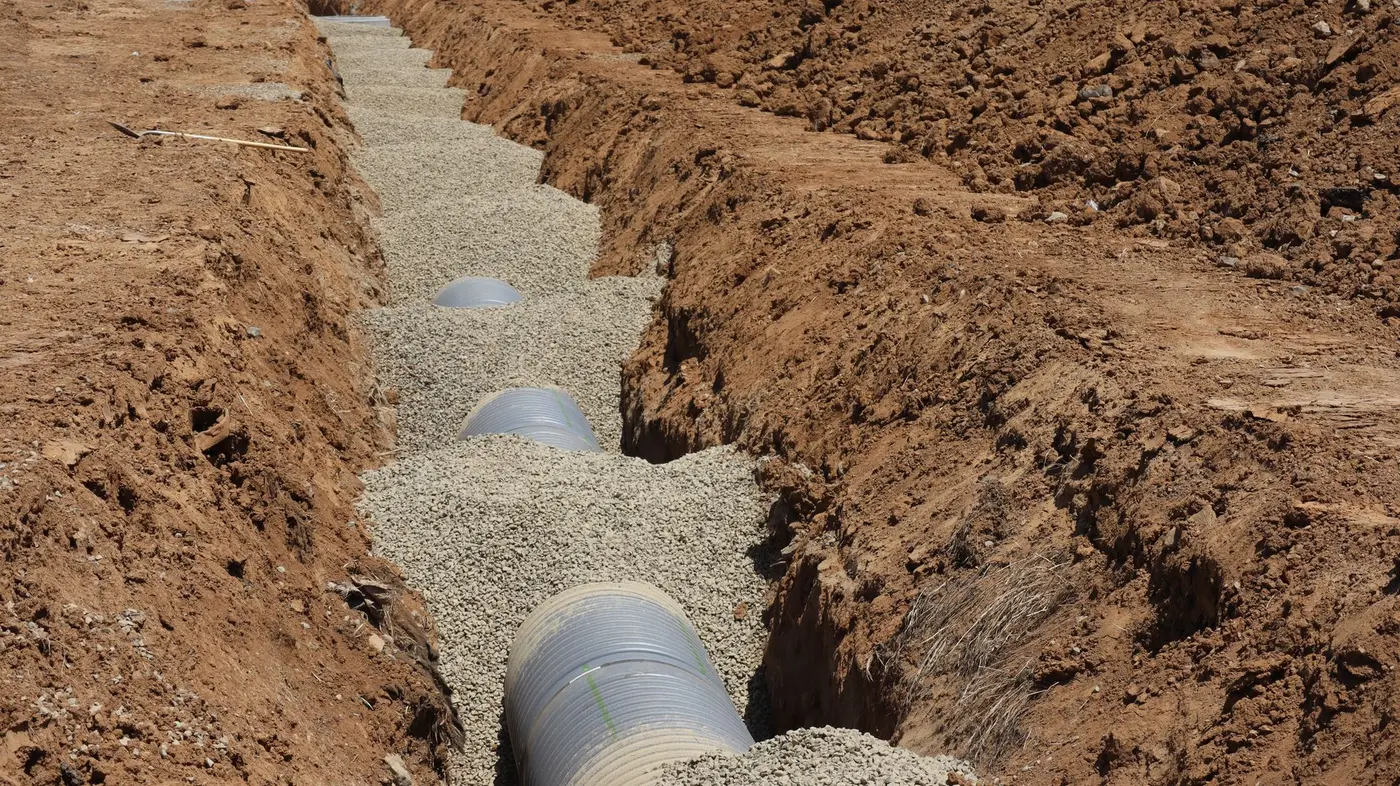 Large sewer pipe section bedded in an open trench during installation