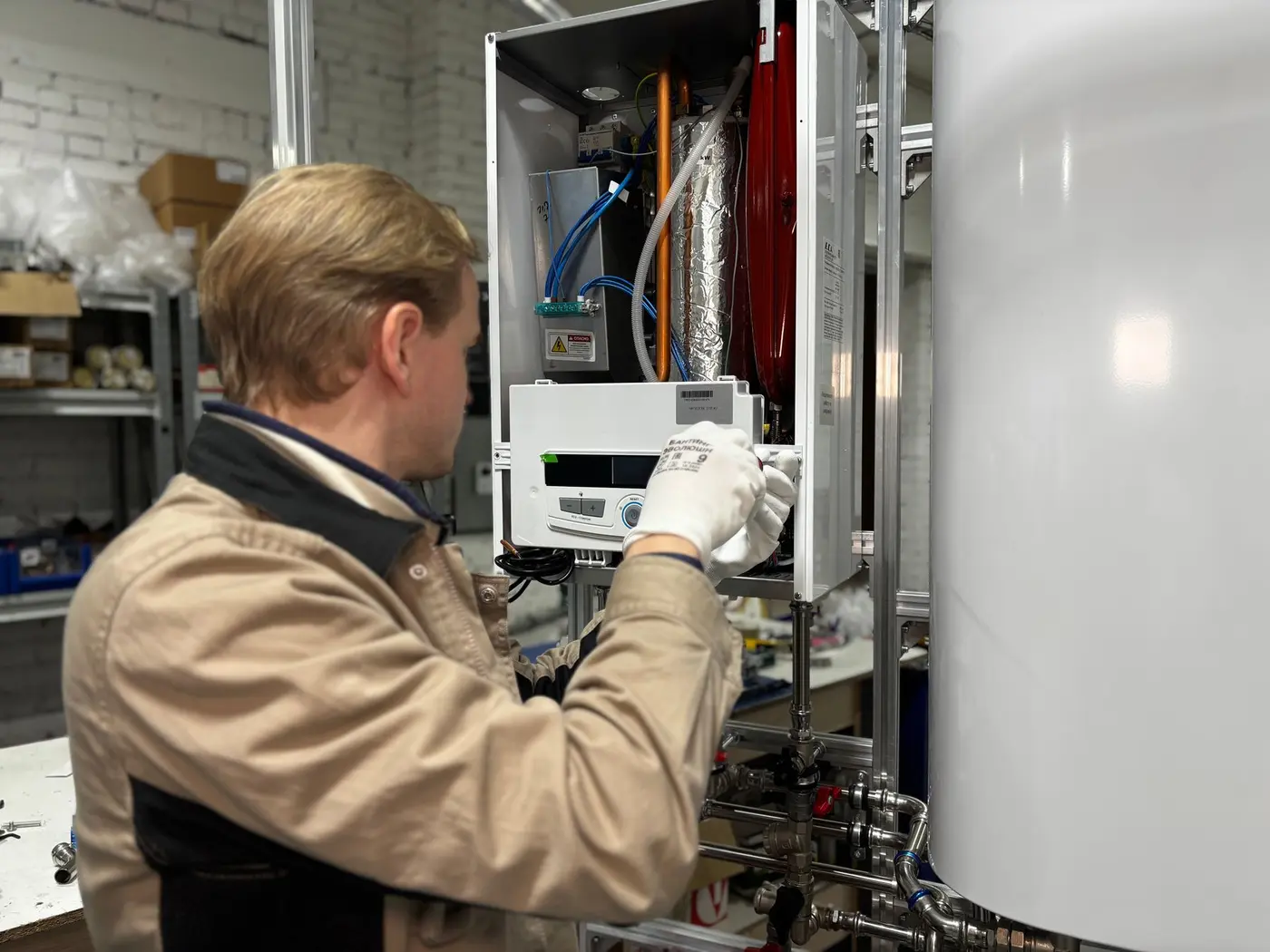 Technician wiring the control panel of a wall-mounted on-demand water heater