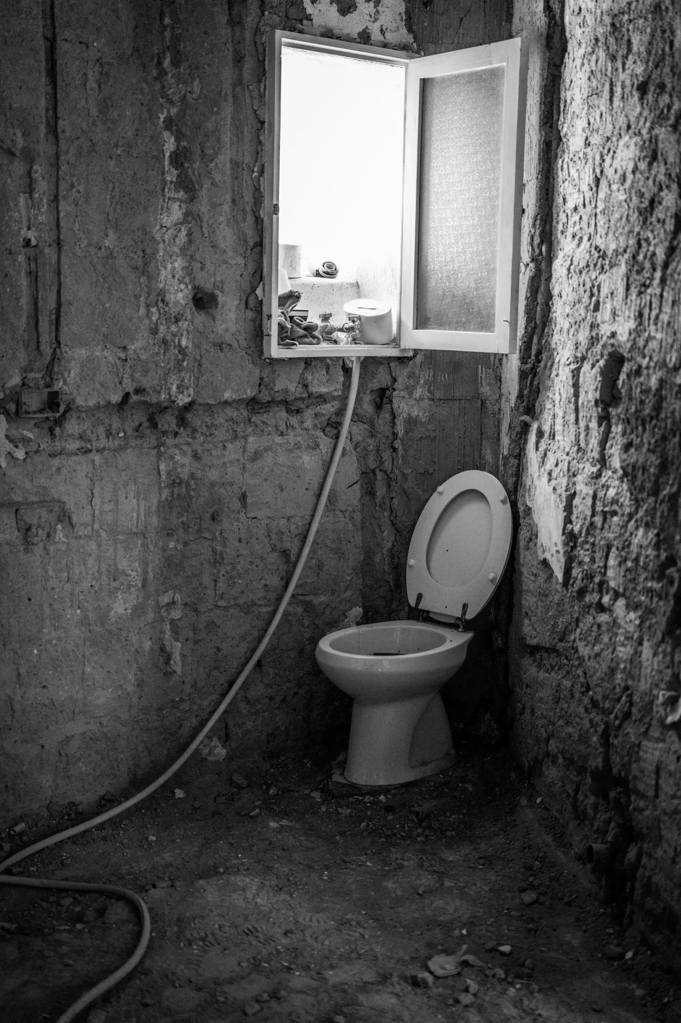 New toilet standing in a stripped bathroom, waiting to be connected